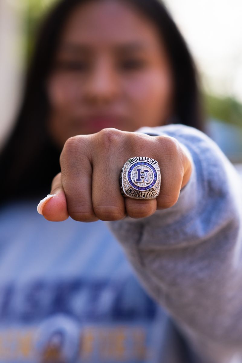Female Native American athlete holding a closed fist out in front of her, showca